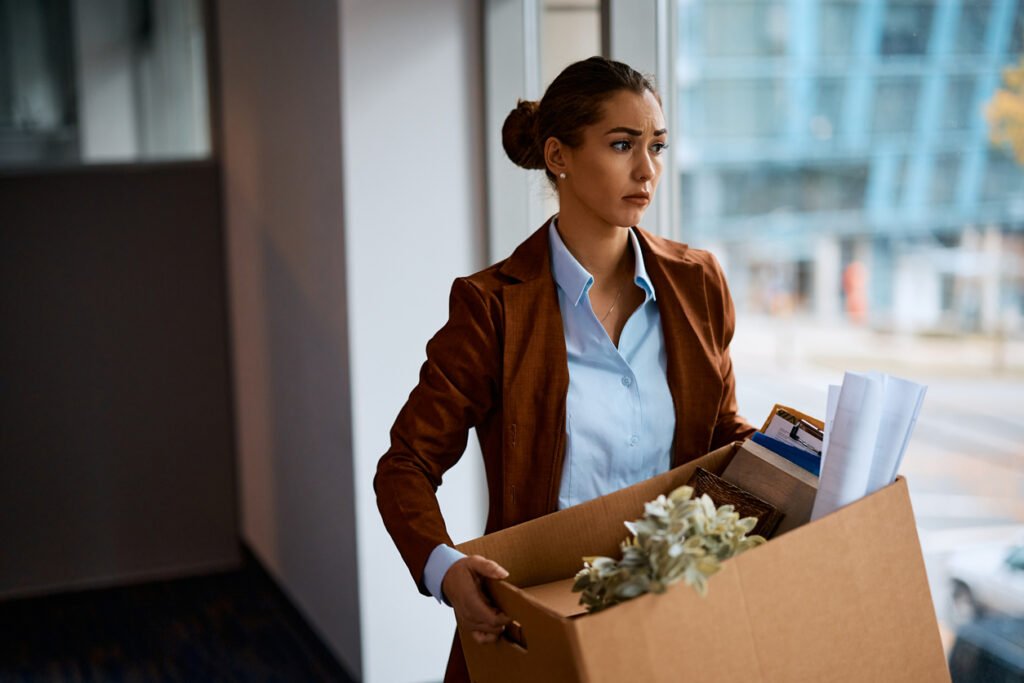 Distraught entrepreneur carrying her belongings after being fired from work. Chômage en Suisse